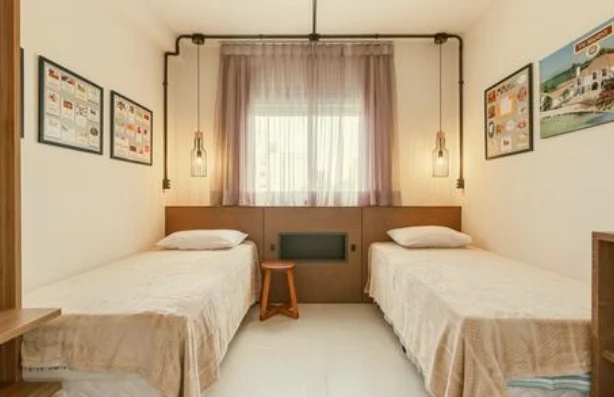 Quarto de apartamento de temporada com duas camas de solteiro arrumadas com enxoval lavado pela Dedicada Lavanderia