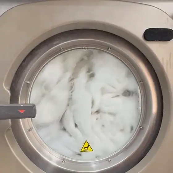 Roupas brancas em lavagem numa máquina industrial da Dedicada Lavanderia, em Florianópolis
