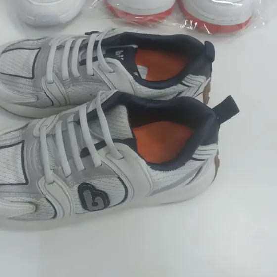 Par de tênis infantil branco com detalhes azul-marinho, lavado na Dedicada Lavanderia